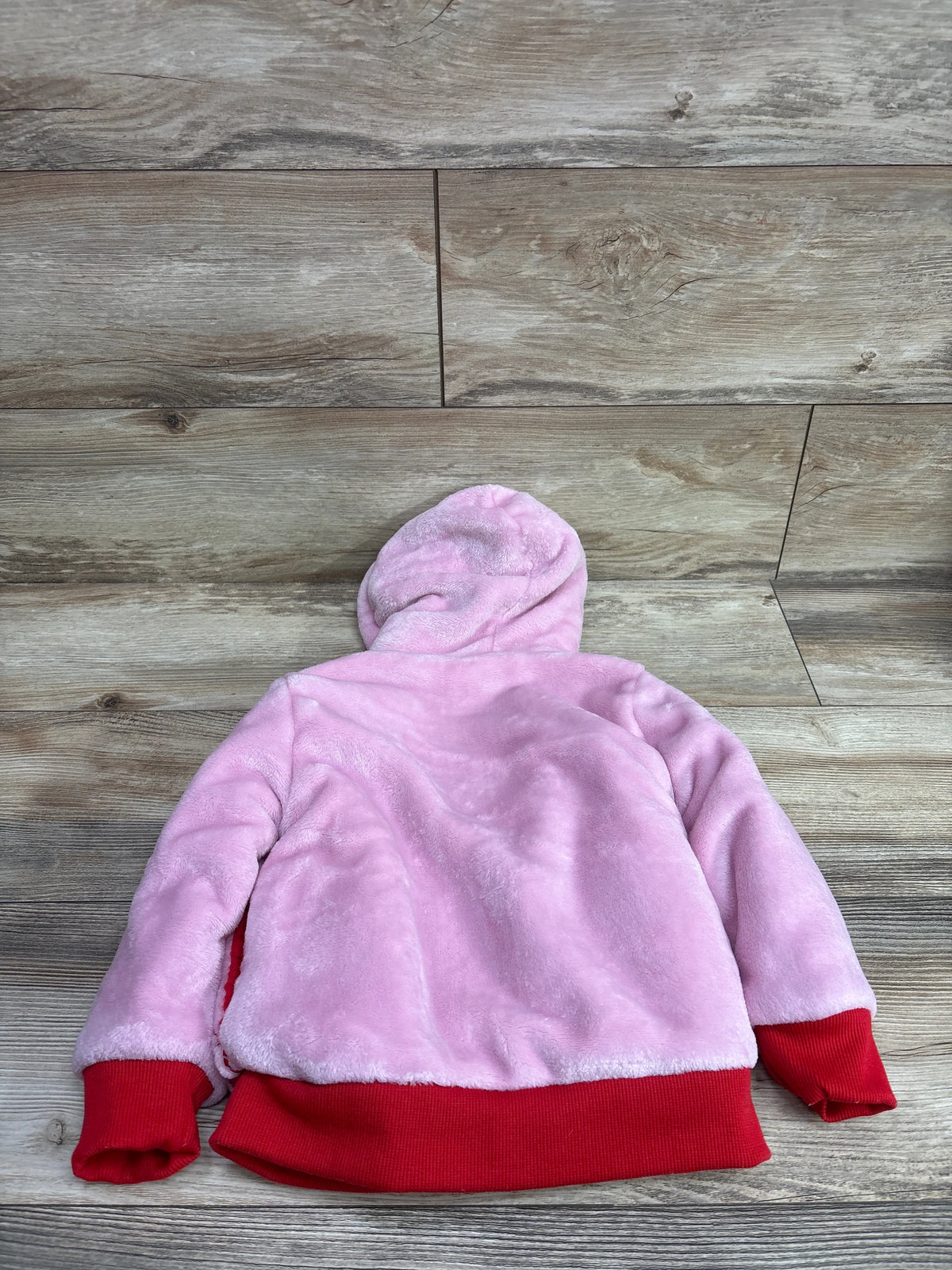 Back view of a pink Disney Junior Minnie Mouse sherpa plush zip-up jacket with red trim.