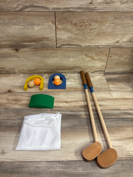 Top view of Mud Pie wooden mini golf toy set showcasing mallets, balls, targets, ramp, and storage bag