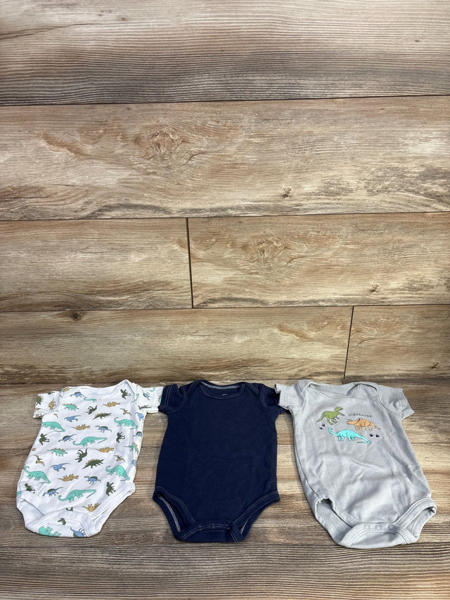 Flat lay of 3-pack Hudson Baby bodysuits size 3-6M showing dinosaur prints and navy bodysuit on wood background