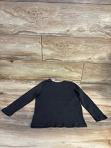 Black long sleeve kids shirt laid flat on wooden surface, children's clothing resale