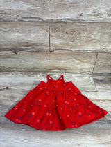 Top-down view of Cat and Jack red toddler tank dress showcasing double spaghetti straps and tiered skirt with pink star and navy leaf print on light wood background