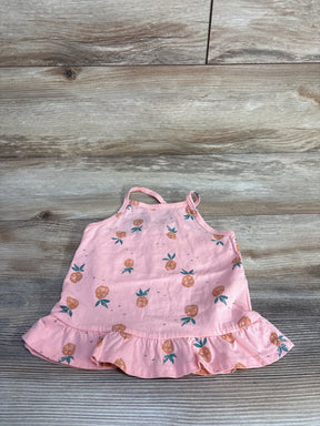 Flat lay of Oshkosh pink pineapple print toddler ruffle tank top 24 months with ruffled hem and thin straps on wood