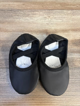Black toddler ballet flats with elastic straps on wood background