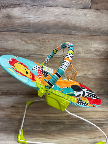 Angled view of Bright Starts Roaming Safari vibrating baby bouncer showcasing colorful safari-print seat and toy bar on a wood floor