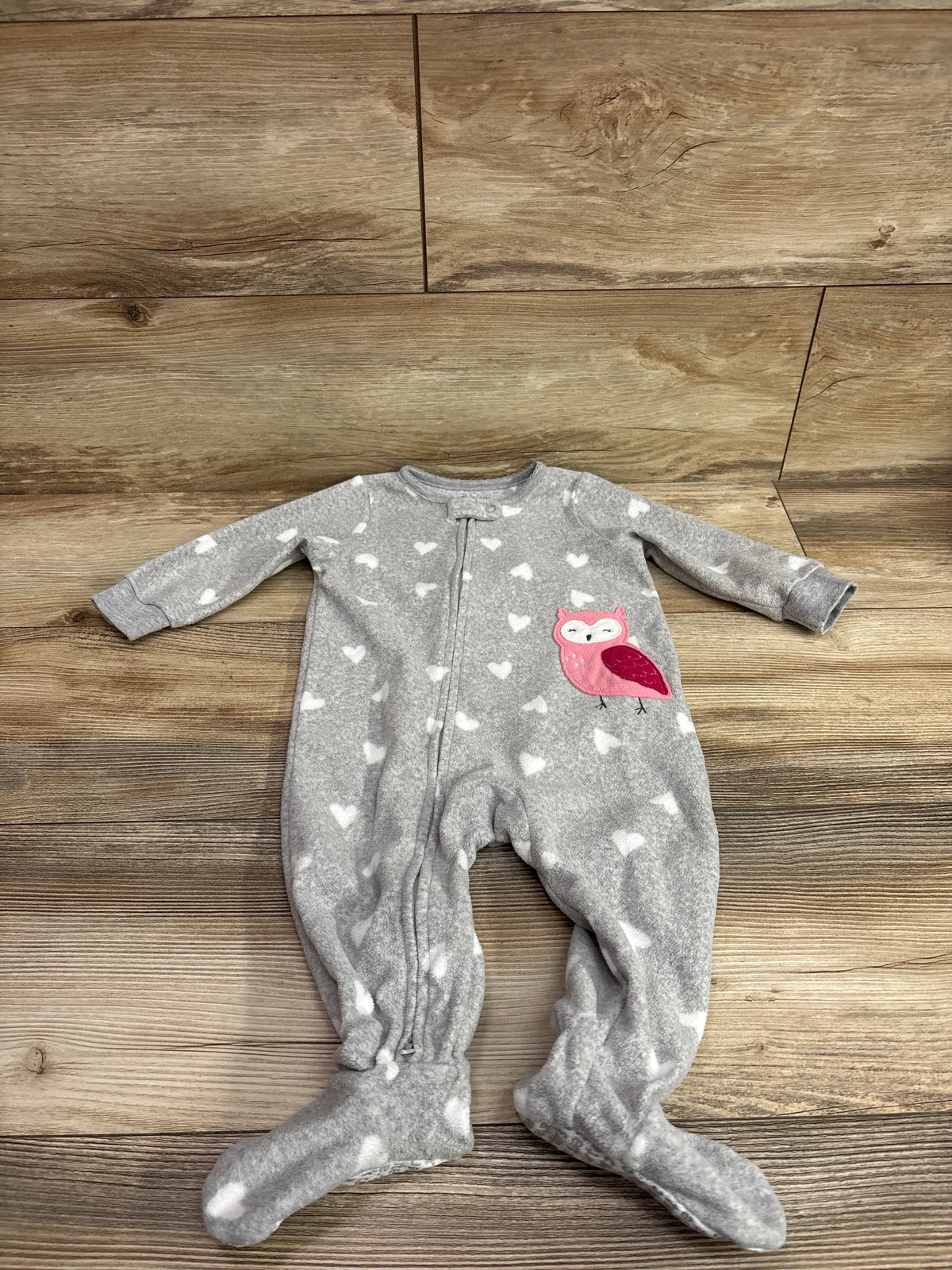Front view of Carter’s gray blanket sleeper with white hearts, pink owl applique, zipper, and covered feet on a wood floor