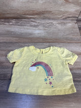 Yellow toddler tee with glitter rainbow, cloud, and stars design on wood floor