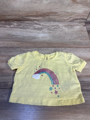 Yellow toddler tee with glitter rainbow, cloud, and stars design on wood floor