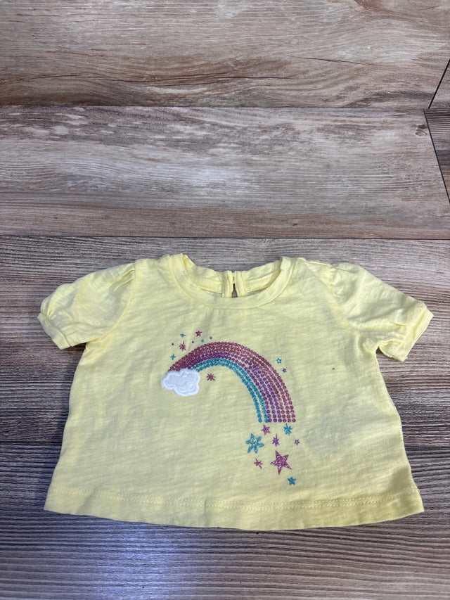 Yellow toddler tee with glitter rainbow, cloud, and stars design on wood floor