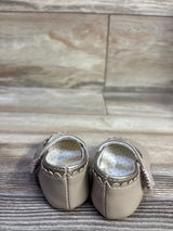 Rear view of tan Mayoral Mary Jane baby shoes showcasing scalloped trim, side flower straps and polka dot lining on wood floor