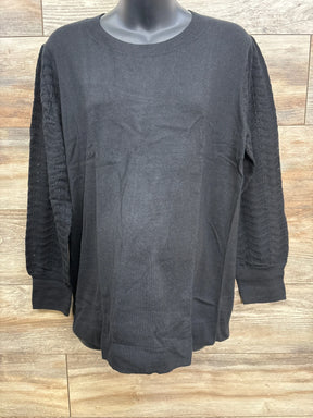 Black long-sleeve knit sweater with lace patterned sleeves on mannequin against wooden background