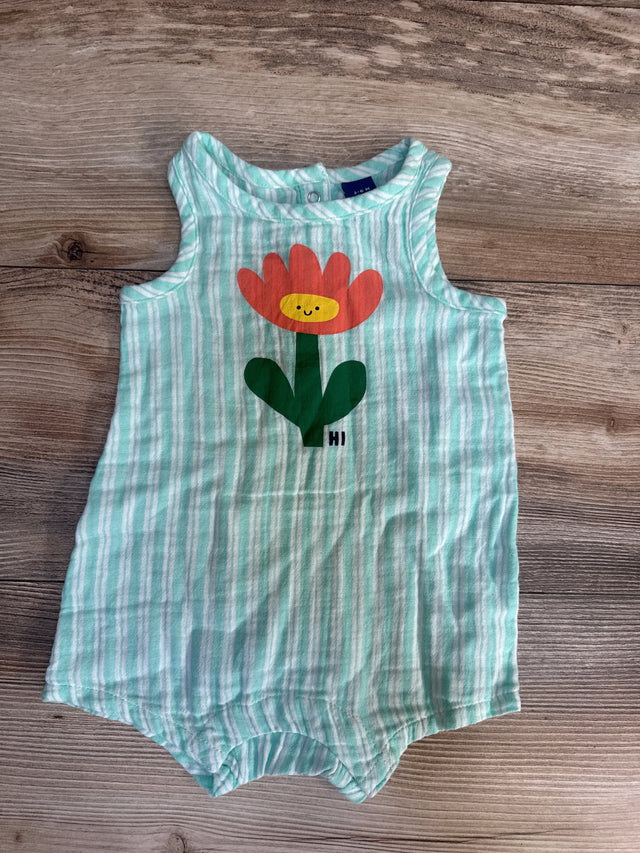 Striped mint green sleeveless baby romper with smiling flower graphic on wood background