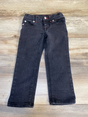 Black kids' jeans with red stitching on wood background, gently used children's clothing