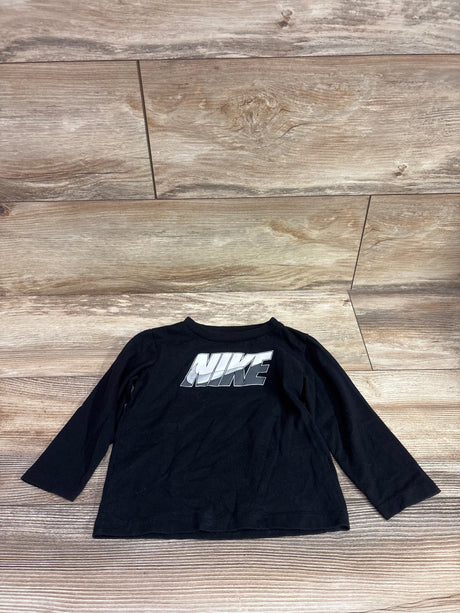 Black long sleeve Nike shirt for toddlers size 18 months on a wood background