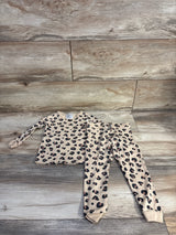 Top-down of H&M 2-piece leopard pajama set 2T showing tan top and matching leggings with black and brown spots on wood