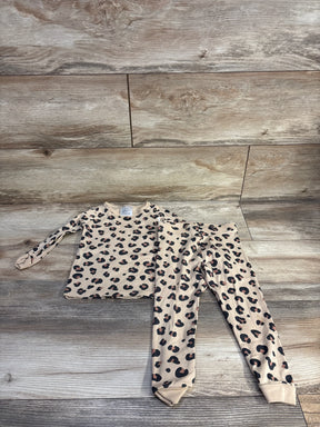 Top-down of H&M 2-piece leopard pajama set 2T showing tan top and matching leggings with black and brown spots on wood