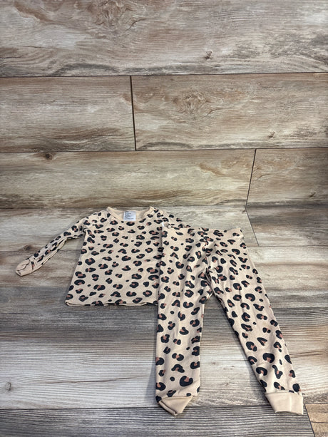 Top-down of H&M 2-piece leopard pajama set 2T showing tan top and matching leggings with black and brown spots on wood