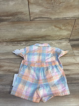 Back flat-lay of toddler two-piece coral pastel plaid shirt and elastic-waist shorts on wood background