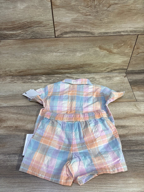 Back flat-lay of toddler two-piece coral pastel plaid shirt and elastic-waist shorts on wood background