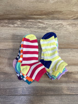 Top-down view of nine-pack baby ankle socks showcasing colorful stripes and contrasting heels with wood-grain background