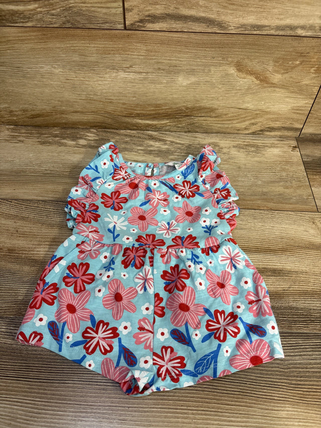 Top-down view of light blue floral shortie romper with pink and red flowers, ruffle sleeves and gathered waist on wood