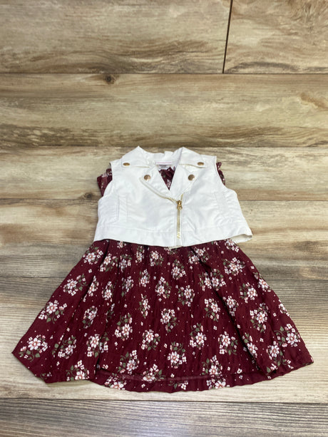 Front view of Little Lass 2-piece faux leather vest and floral dress set in white and burgundy on a wood background
