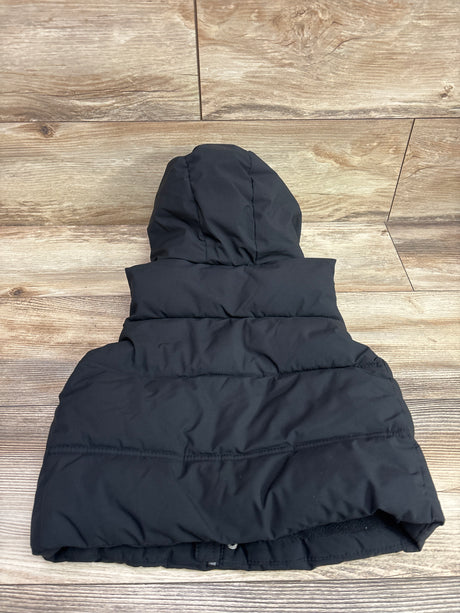 Back view of Zara hooded puffer vest, black, size 2/3T, showcasing horizontal quilting on a wood-look floor