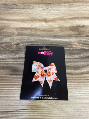 Pink gingerbread-themed hair bow for kids, festive holiday accessory on black card