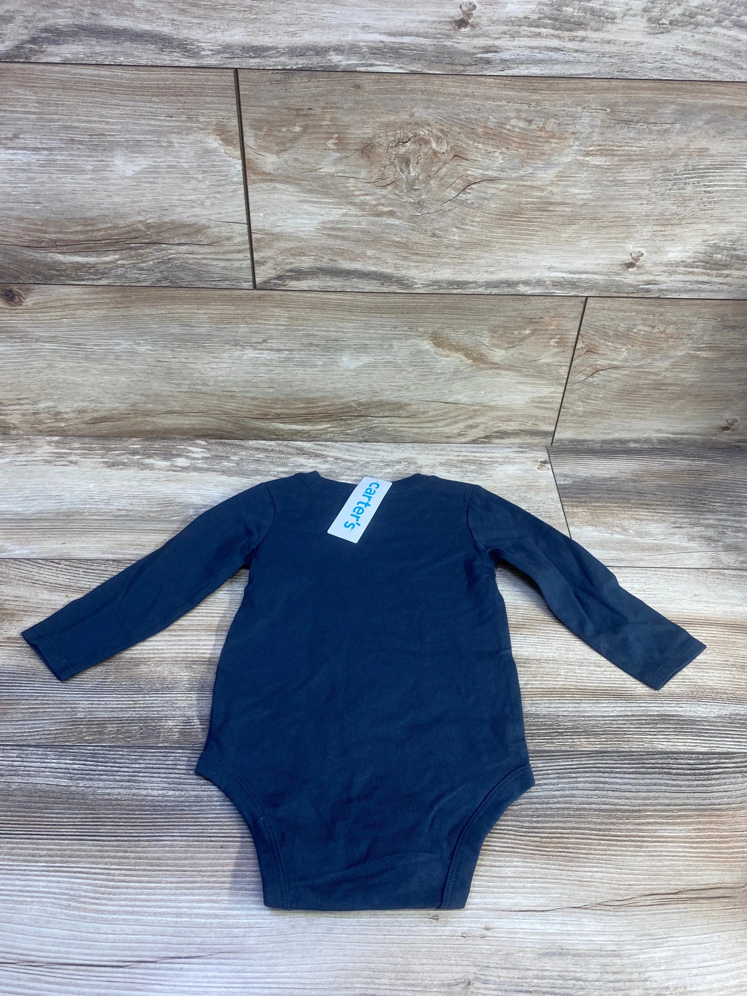 Top-down view of Carter’s Daddy’s Girl long-sleeve bodysuit on a wood-look floor