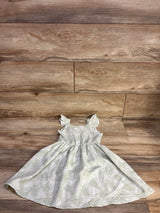 Flat lay of Little Lass smocked girls' dress in pale green with white leaf print, ruffle sleeves, gathered skirt, 4T