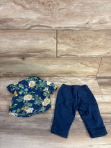 Flat lay of newborn Old Navy navy floral button-up shirt and matching navy elastic-waist pants on light wood background