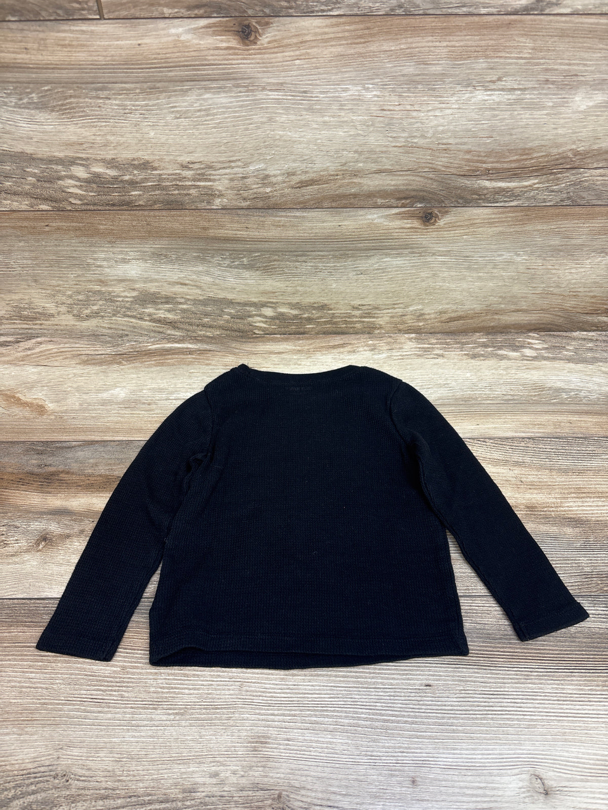 Front view of Old Navy black thermal shirt in size 3T showcasing long sleeves and ribbed knit texture with a wood background