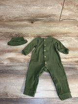 Olive green ribbed baby romper with matching hat, wooden buttons, laid on wood floor