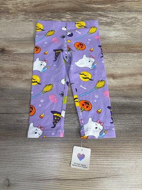 Purple Halloween leggings for kids with ghosts, pumpkins, witches' hats, and candy corn print on wood background