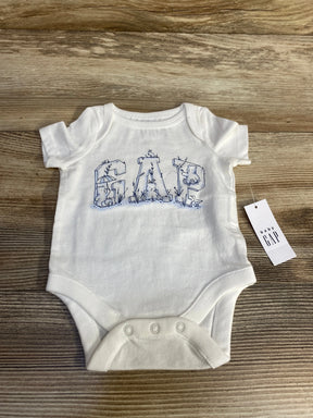 Front of white newborn Baby Gap bodysuit with blue GAP animal print letters, three snaps, and tag on wood surface