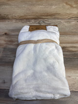 Front view of NEW DreamGro doll and baby blanket in white plush showcasing folded packaging with kraft hangtag on wood plank floor