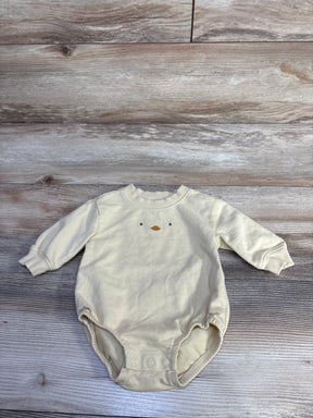 Flat lay of yellow baby bubble romper with embroidered duck face and three snap crotch closures on wood background