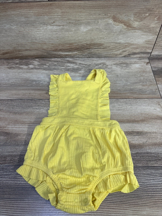 Front flat lay of yellow ribbed bubble romper size 12M with ruffled straps, snap crotch, and skirt on wood floor