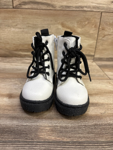 Front view of Sincerely Jules white faux-leather boots, size 6C, with black laces and chunky soles on wood-look flooring
