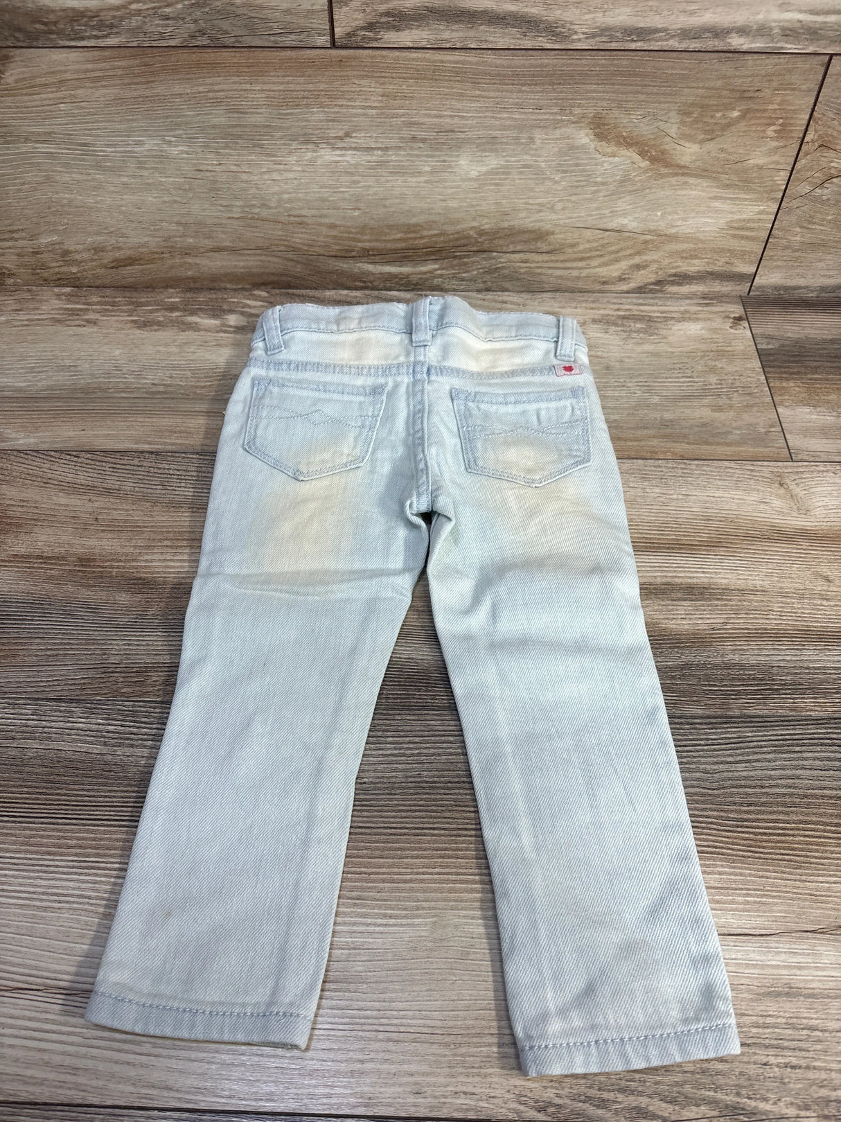 Back view of Lucky Brand Zoe toddler jeggings (2T) showcasing rear patch pockets and faded wash on wood floor background