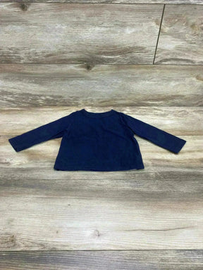 Flat lay of navy Children's Place long-sleeve baby shirt (9-12 months) showing crew neck and straight hem on wood floor