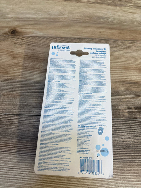 Back view of Dr. Brown's Straw Cup Replacement kit packaging showing care instructions and barcode on wooden surface