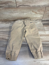 Beige Volcom kids jogger pants with elastic waist and cuffs, laid flat on wood floor