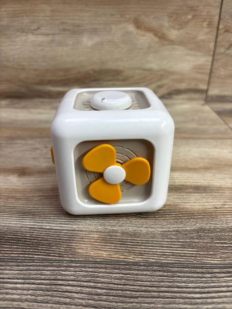 Front view of Montessori busy cube showcasing a yellow propeller and white top knob with a wood background