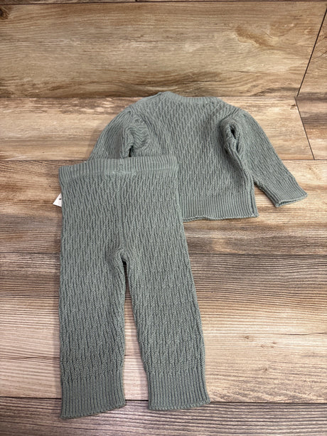 Jessica Simpson 2-piece sage green knit sweater and pants set for infants on a wood background