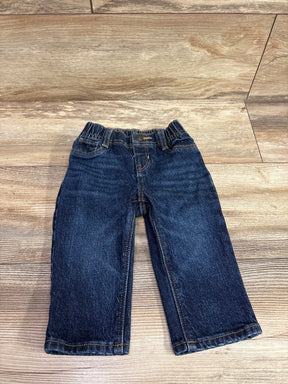 Dark wash navy blue baby jeans for size 6-12m laid flat on a wooden surface.