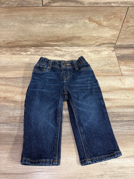 Dark wash navy blue baby jeans for size 6-12m laid flat on a wooden surface.
