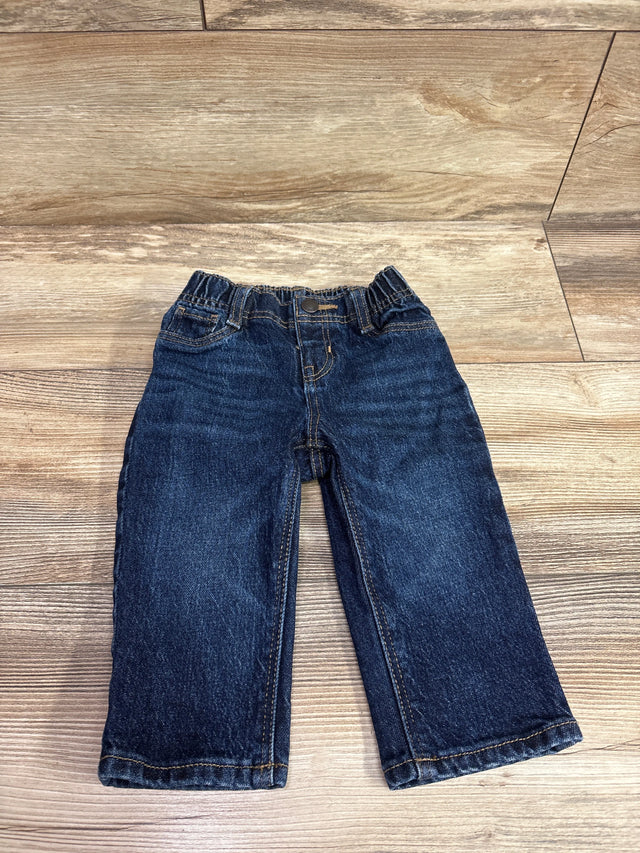 Dark wash navy blue baby jeans for size 6-12m laid flat on a wooden surface.