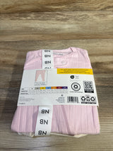 Top view of folded newborn purple Member's Mark 3pk sleep set with ribbed fabric and two-way zipper on wood background