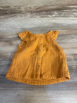 Front view flat lay of Cat and Jack gauze button-up shirt in mustard orange size 3-6m with flutter sleeves on wood plank floor