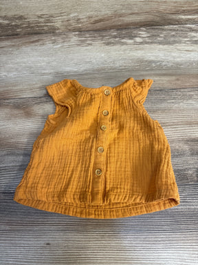 Front view flat lay of Cat and Jack gauze button-up shirt in mustard orange size 3-6m with flutter sleeves on wood plank floor